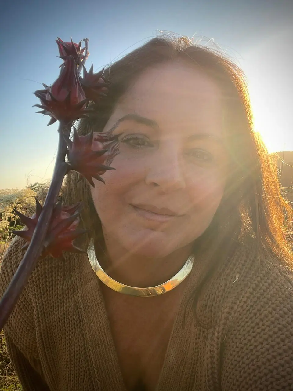 Foto de Adriana Campos na natureza sob a luz do sol